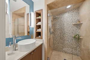 Bathroom featuring vanity, a stall shower, and built in features