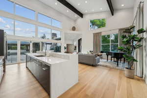 Kitchen with a sink, beam ceiling, modern cabinets, light wood finished floors, and open floor plan