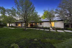 Mid-century home featuring a front yard, a standing seam roof, metal roof, and brick siding