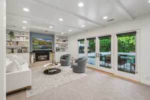Living area featuring beamed ceiling, recessed lighting, and a glass covered fireplace