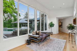 Living area with wood finished floors, baseboards, and recessed lighting