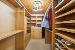 Walk in closet featuring light carpet and a chandelier