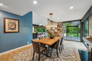 Dining room with a chandelier, wood finished floors, plenty of natural light, baseboards, and recessed lighting