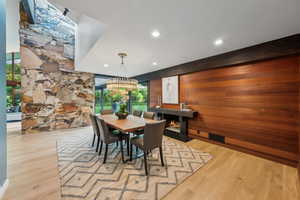 Dining room featuring a fireplace with flush hearth, recessed lighting, and wood finished floors