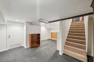 Finished below grade area with stairs, recessed lighting, baseboards, and carpet flooring