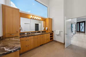 Pool Guest Bathroom featuring a high ceiling, vanity, and baseboards