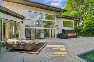 View of patio with an outdoor living space with a fireplace and area for grilling