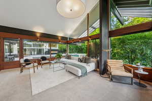 Sunroom / solarium with carpet and high vaulted ceiling