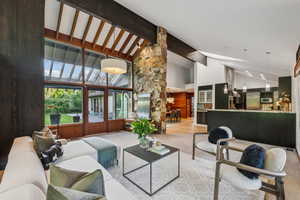 Living area featuring high vaulted ceiling, beam ceiling, and carpet flooring