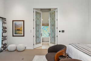 Bedroom featuring light colored carpet and baseboards