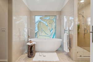 Full bath with speckle patterned floor, lofted ceiling, a stall shower, radiator, and a freestanding tub