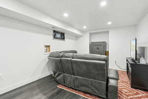 Living area with recessed lighting, dark wood finished floors, and baseboards