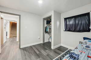Bedroom with wood finished floors and baseboards