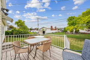 Deck featuring outdoor dining space and a yard