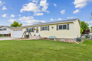 Ranch-style home featuring an attached garage, concrete driveway, and central AC unit