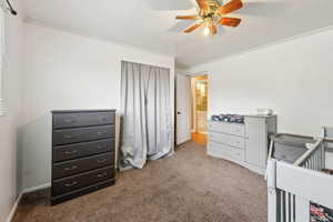 Bedroom with carpet, crown molding, baseboards, and a ceiling fan