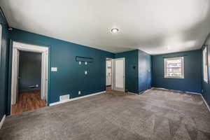 Carpeted spare room featuring baseboards
