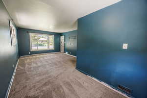 Carpeted spare room with baseboards