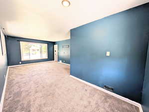 Empty room featuring carpet floors and baseboards