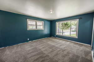 Carpeted empty room with baseboards