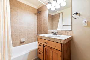 Bathroom featuring shower / tub combo, vanity, and a chandelier