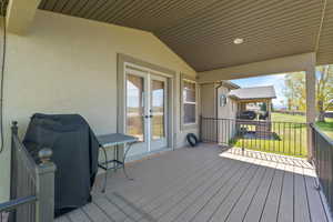 Wooden terrace featuring area for grilling, french doors, and a yard