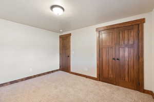 Unfurnished bedroom with carpet flooring, baseboards, and a closet