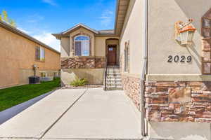 Entrance to property with stone siding and stucco siding