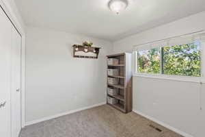 Carpeted empty room with baseboards and a textured ceiling