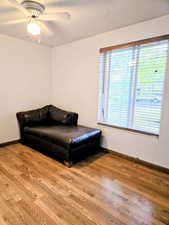 Sitting room featuring plenty of natural light, light wood-type flooring, ceiling fan, and baseboards