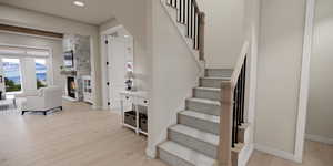 Stairway featuring wood finished floors, recessed lighting, and a fireplace