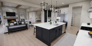 Kitchen with dark cabinets, decorative light fixtures, light wood finished floors, a kitchen island with sink, and light stone counters
