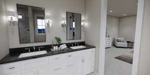 Ensuite bathroom featuring double vanity and light carpet