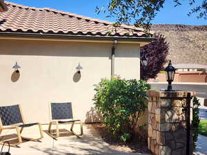 View of home's exterior with stucco siding, a tile roof, a mountain view, and a patio area