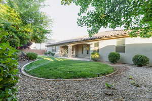 Rear view of house featuring a tile roof, stucco siding, and a patio