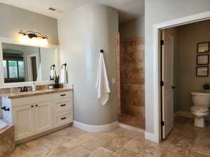 Bathroom featuring vanity, walk in shower, baseboards, and toilet