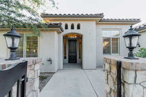 View of exterior entry featuring stucco siding and a tiled roof