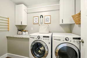 Washroom with washing machine and clothes dryer and cabinet space