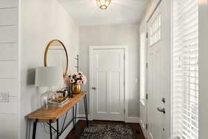 Foyer entrance featuring dark wood-type flooring and baseboards