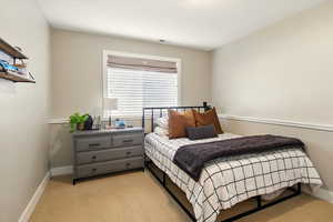 Bedroom with light colored carpet and baseboards