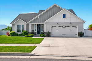 Craftsman-style home with board and batten siding, an attached garage, roof with shingles, driveway, and a mountain view