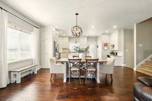 Dining area with a chandelier, recessed lighting, dark wood-style flooring, stairway, and baseboards