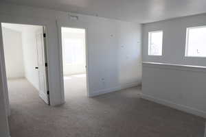 Unfurnished room featuring carpet floors and baseboards