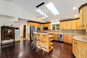 Corian Counters, New Lighting, Skylights, Tile Backsplash, Wood Flooring, Custom Cabinets, Island with Prep Sink