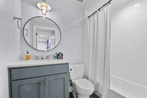 Bathroom featuring vanity, toilet, and shower / tub combo