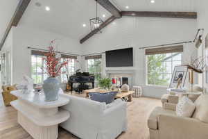 Living area featuring recessed lighting, high vaulted ceiling, hardwood / wood-style flooring, a chandelier, and a fireplace