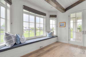 Unfurnished room with light wood finished floors, baseboards, and wood ceiling with exposed beams
