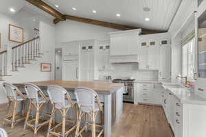 Kitchen with premium range, a sink, wooden counters, light wood-type flooring, and backsplash