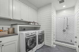 Laundry area with washing machine and clothes dryer, dark tile patterned flooring, cabinet space, and recessed lighting