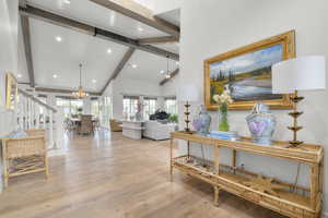Living room with beamed ceiling, a chandelier, light wood-type flooring, recessed lighting, and high vaulted ceiling